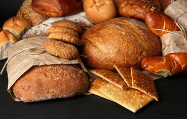 Different types of bread on black background, close-up