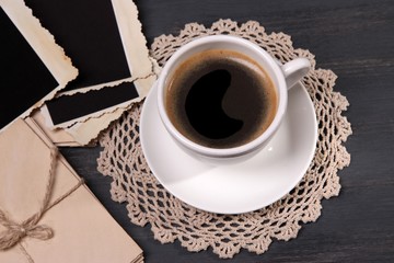 Coffee cup and old blank photos, on wooden background