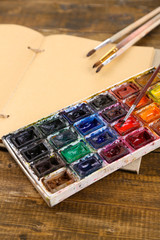 Composition with colorful watercolors, brushes and sketcher