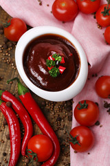 Tomato sauce in bowl on wooden table close-up