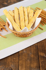 Bread sticks  in wicker basket on wooden background