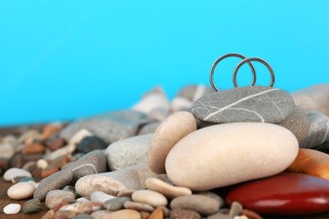 Wedding rings on rocks on blue background