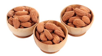 Almond in wooden bowls, isolated on white