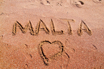 the word Malta on the sand