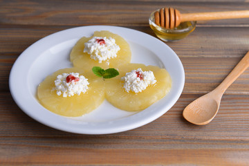 Tasty pineapple with cottage cheese on  wooden table