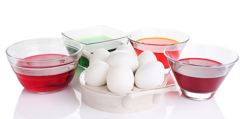 Eggs with liquid colour in glass bowls isolated on white