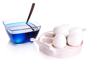 Eggs with liquid colour in glass bowl isolated on white