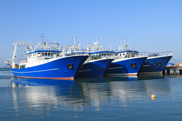 Fishing ships docked in port - 63191271