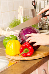 housewife cuts red cabbage at home with knife