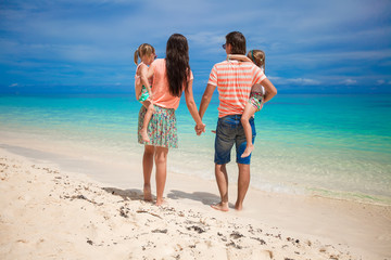 Back view family of four on beach vacation