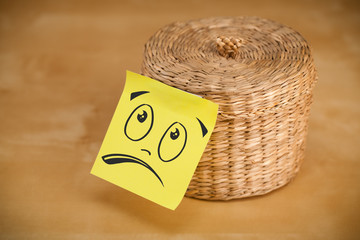 Post-it note with smiley face sticked on jewelry box