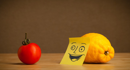 Lemon with post-it note smiling at tomato