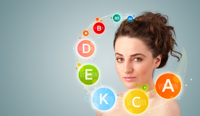 Pretty young girl with colorful vitamin icons and symbols