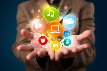 Young businessman presenting colorful technology icons and symbo