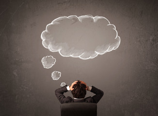 Businessman sitting with cloud thought above his head