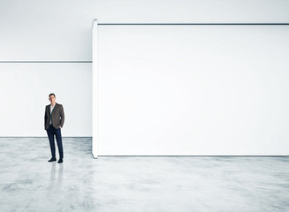 Businessman standing in empty bright office