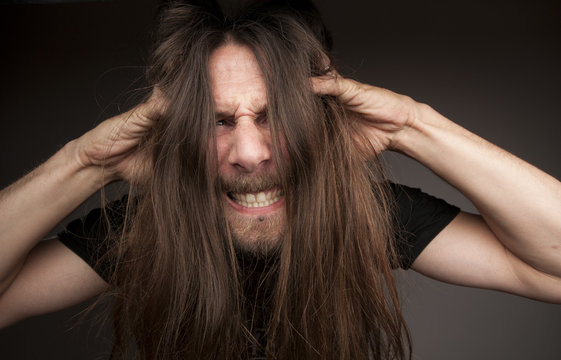 Hombre gritando y tirandose los pelos. Locura. Loco