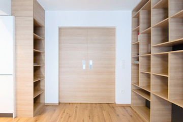 empty bookshelves and closed door in empty apartment