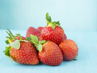 handful of strawberries on blue background