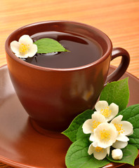 Tea cup with jasmine flower on the wood