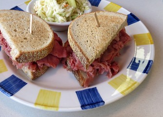 Corned beef sandwich on toasted rye bread, served with coleslaw.