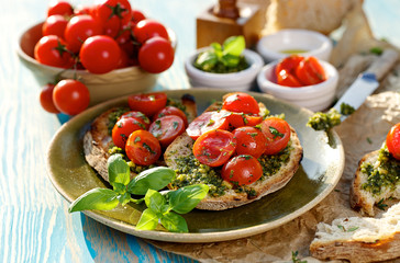 Bruschetta with fresh cherry tomatoes and aromatic herb pesto