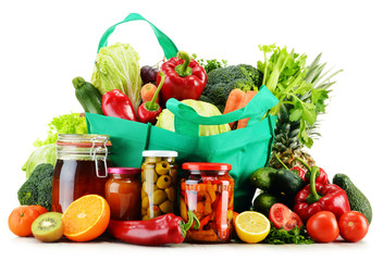 Green shopping bag with groceries isolated on white