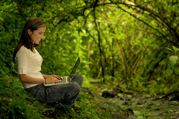 woman in the forest using a laptop