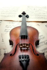 Old scratched violin on music sheet. Vintage style.