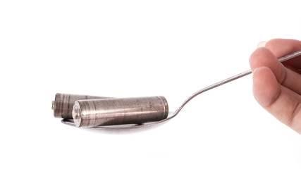 isolated of old AA battery in spoon is energy consumption concep