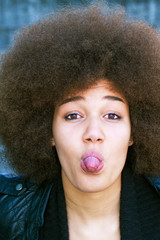 Young woman with afro hair cut sticking tongue out