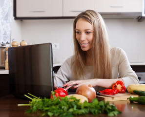 Smiling woman  with notebook in  kitchen