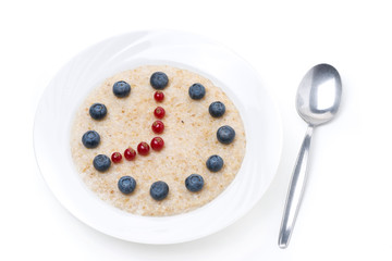 oatmeal with berries in the form of dial and spoon, isolated