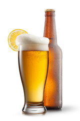 Beer in glass with lemon and bottle isolated on white