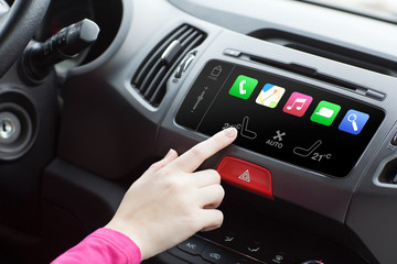 woman sitting in a car and touch play finger in a auto smart sys