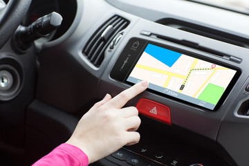 woman sitting in a car and touch play finger in a navigation map