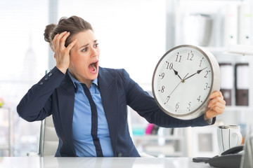 Stressed business woman looking on clock