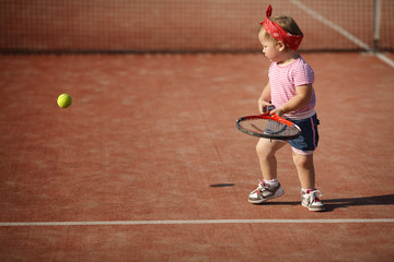 little girl plays tennis