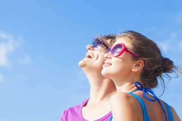 happy young couple in sunglasses smiling looking at the sky