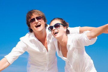 Closeup of happy young couple in white clothes and sunglasses