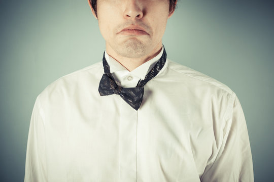 Sad young man with messy bow tie