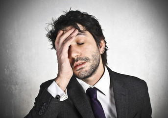 Stressed businessman with hand on the head