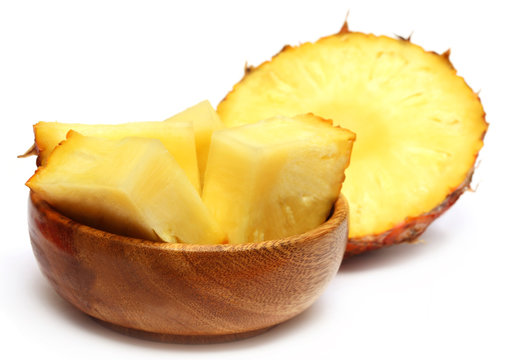 Sliced pineapple on a wooden bowl