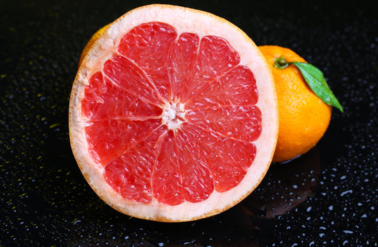 Ripe sweet tangerine and grapefruit, on dark color background