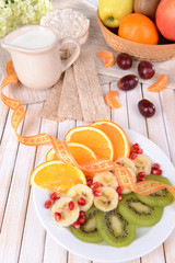 Sweet fresh fruits on plate on table close-up