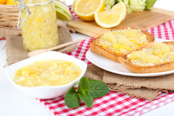 Delicious toasts with lemon jam on plate on table close-up