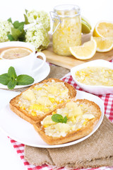 Delicious toasts with lemon jam on plate on table close-up