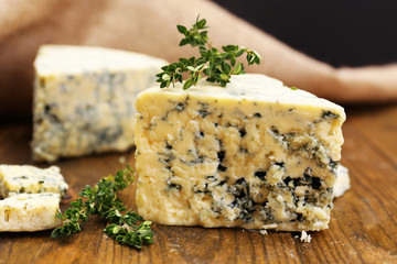 Tasty blue cheese with thyme, on wooden table