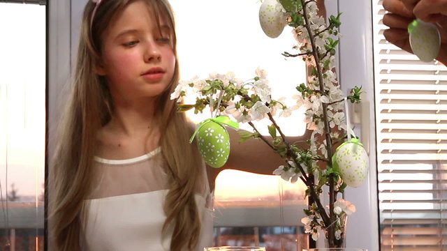 Happy family with child hang easter egg.