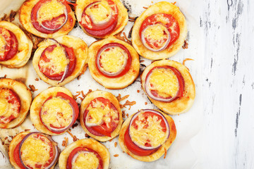 Small pizzas on baking paper close up